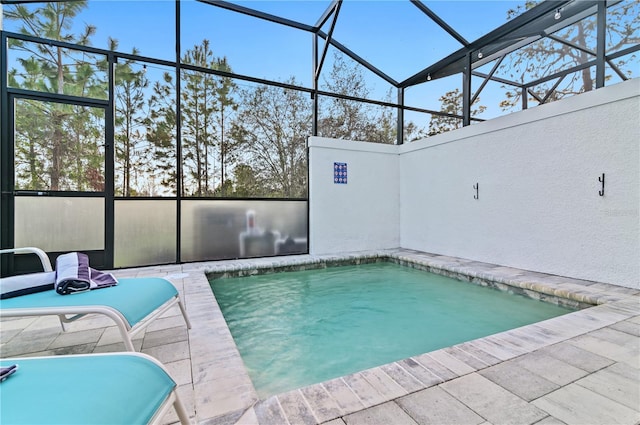 view of swimming pool featuring glass enclosure