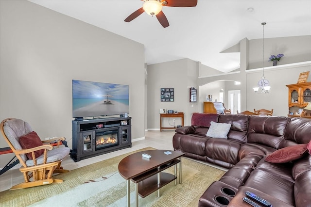 living room featuring ceiling fan with notable chandelier, vaulted ceiling, and light tile patterned floors