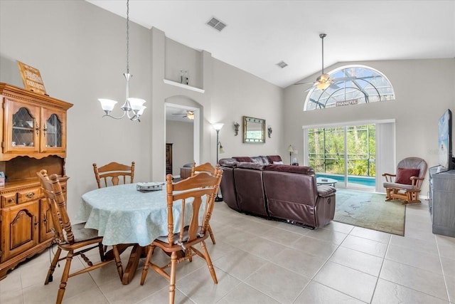 tiled dining area with ceiling fan with notable chandelier and high vaulted ceiling