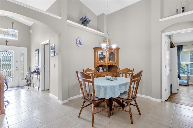 tiled dining room featuring high vaulted ceiling