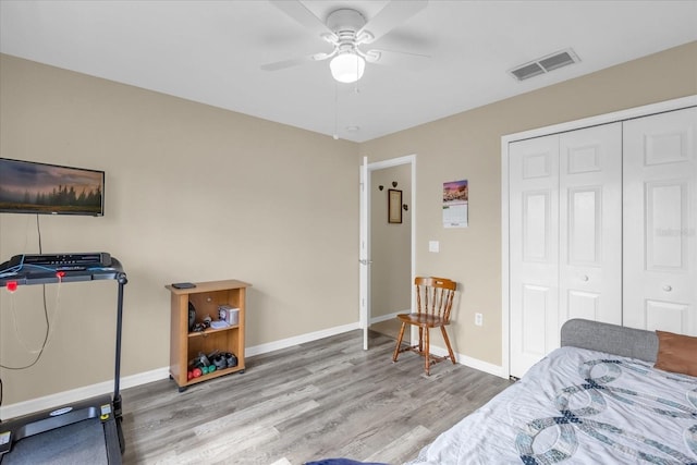 bedroom featuring ceiling fan, light wood-type flooring, and a closet