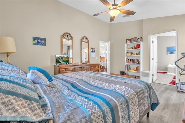 bedroom with hardwood / wood-style flooring, vaulted ceiling, and ceiling fan