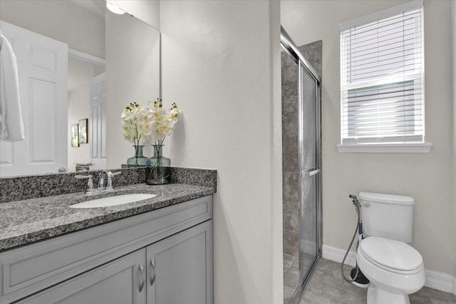 bathroom with toilet, vanity, tile patterned floors, and a shower with shower door