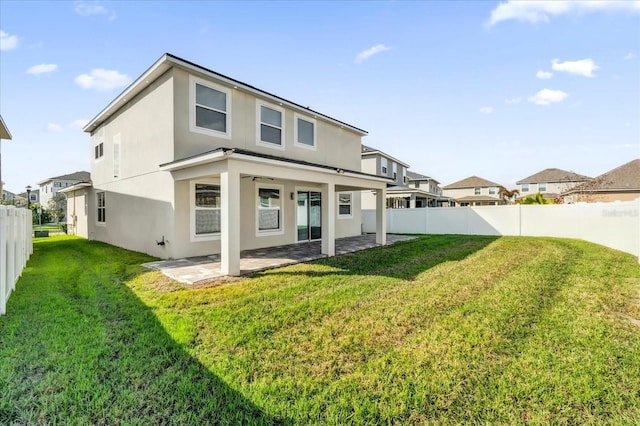 back of house with a yard and a patio