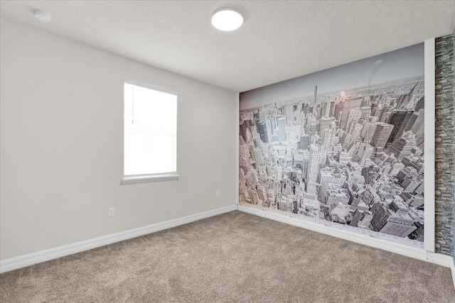 carpeted empty room featuring a textured ceiling