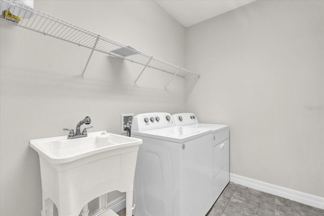 clothes washing area featuring independent washer and dryer and sink