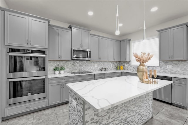 kitchen with gray cabinets, tasteful backsplash, appliances with stainless steel finishes, and light stone counters