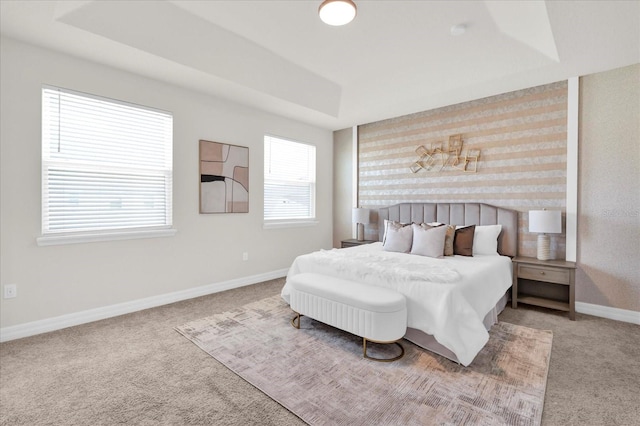 carpeted bedroom featuring a tray ceiling