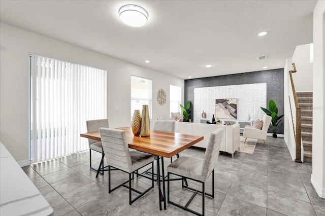 tiled dining room featuring a textured ceiling