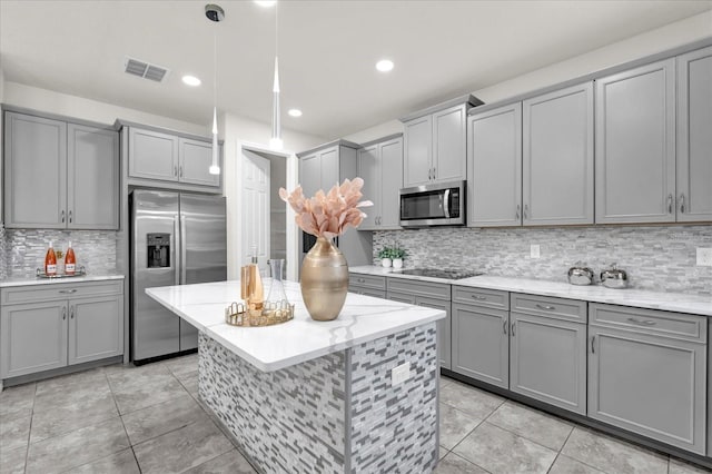 kitchen featuring pendant lighting, stainless steel appliances, gray cabinets, and light tile patterned floors