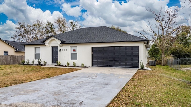 ranch-style house featuring a garage, central AC, and a front lawn