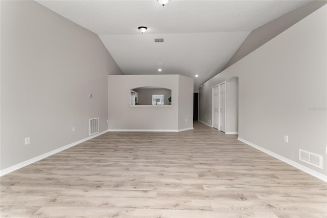 unfurnished living room featuring lofted ceiling and light wood-type flooring