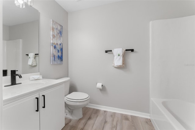 full bathroom with vanity, hardwood / wood-style flooring, shower / washtub combination, and toilet