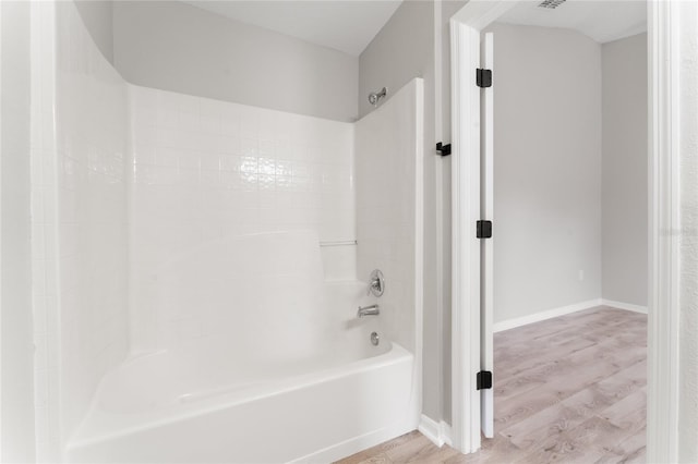 bathroom with hardwood / wood-style flooring and shower / bathtub combination