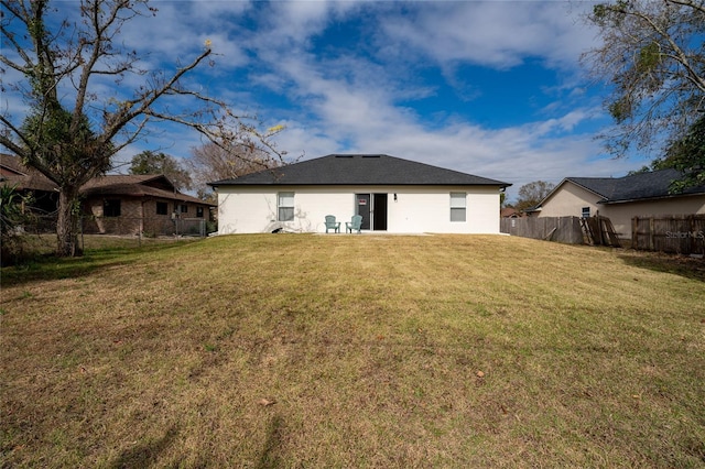 rear view of property featuring a lawn