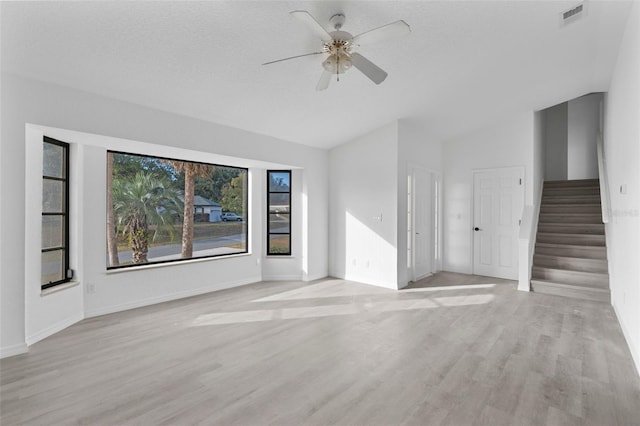 unfurnished living room featuring lofted ceiling, a textured ceiling, ceiling fan, and light hardwood / wood-style flooring