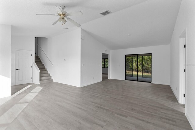 unfurnished living room with vaulted ceiling, ceiling fan, and light wood-type flooring