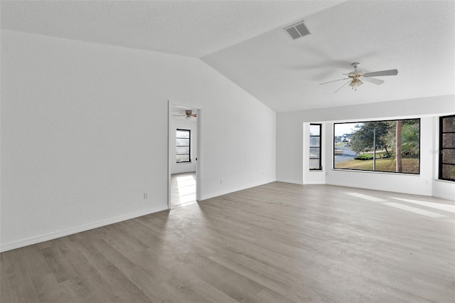 unfurnished living room featuring lofted ceiling, a textured ceiling, light hardwood / wood-style floors, and ceiling fan