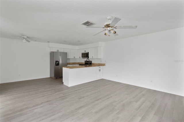 kitchen with white cabinetry, kitchen peninsula, ceiling fan, stainless steel appliances, and light hardwood / wood-style floors