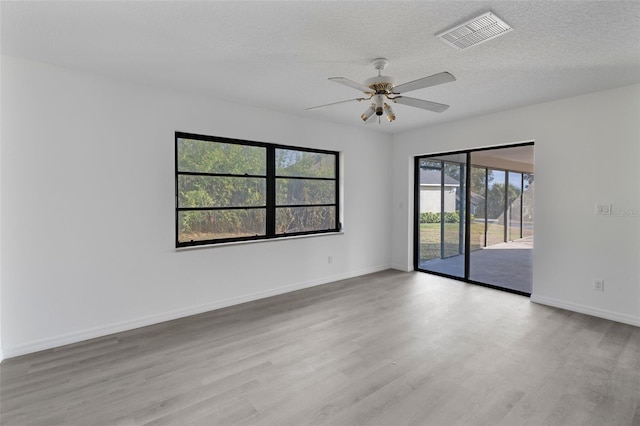 unfurnished room featuring ceiling fan, a textured ceiling, and light wood-type flooring