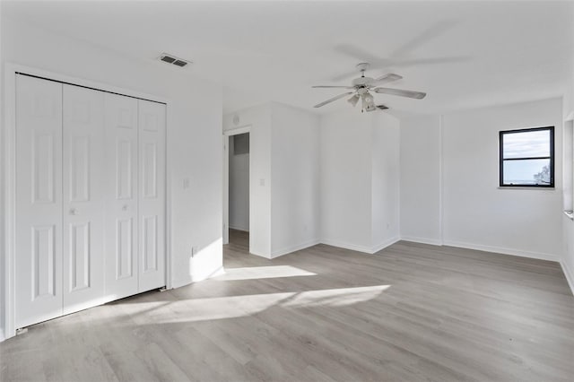 unfurnished bedroom with ceiling fan, a closet, and light hardwood / wood-style flooring