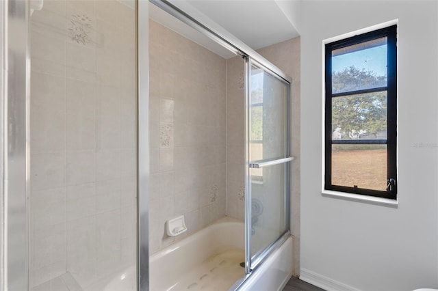 bathroom with bath / shower combo with glass door