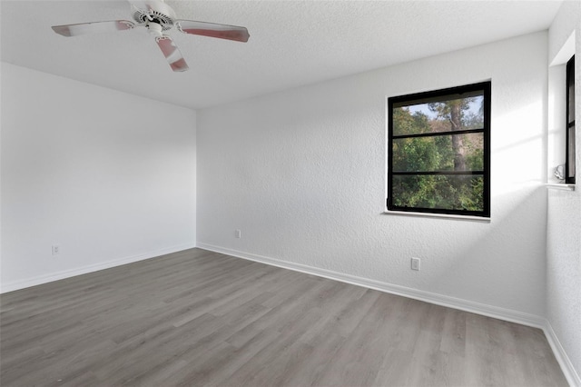 spare room with hardwood / wood-style flooring, ceiling fan, and a textured ceiling