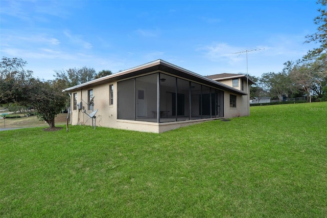 rear view of property with a sunroom and a lawn