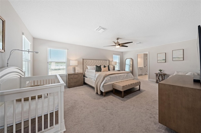 carpeted bedroom with ceiling fan and a textured ceiling