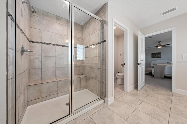 bathroom with tile patterned floors, toilet, an enclosed shower, and a textured ceiling