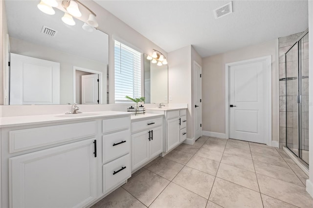 bathroom featuring tile patterned flooring, a notable chandelier, vanity, and a shower with door