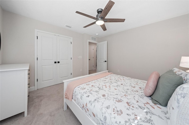 bedroom with ceiling fan, a closet, and light carpet