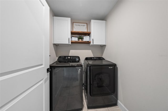 washroom with washer and clothes dryer, cabinets, and light tile patterned flooring