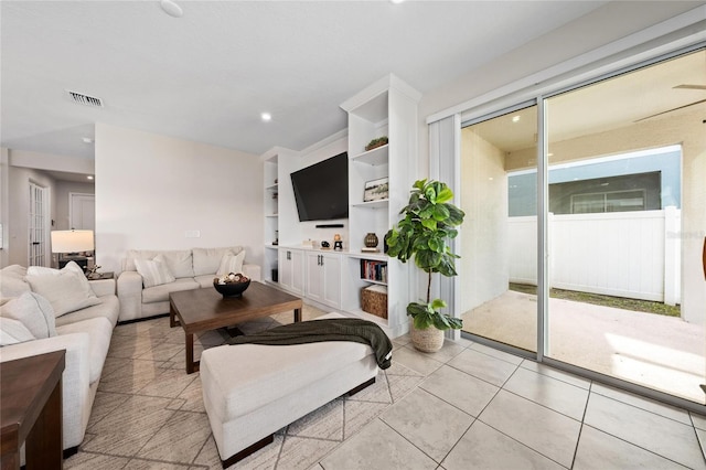 living room featuring light tile patterned flooring and built in features