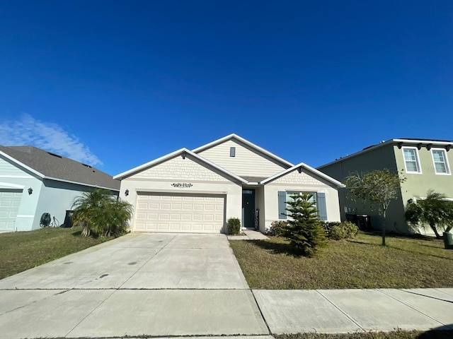 ranch-style home with a garage and a front lawn