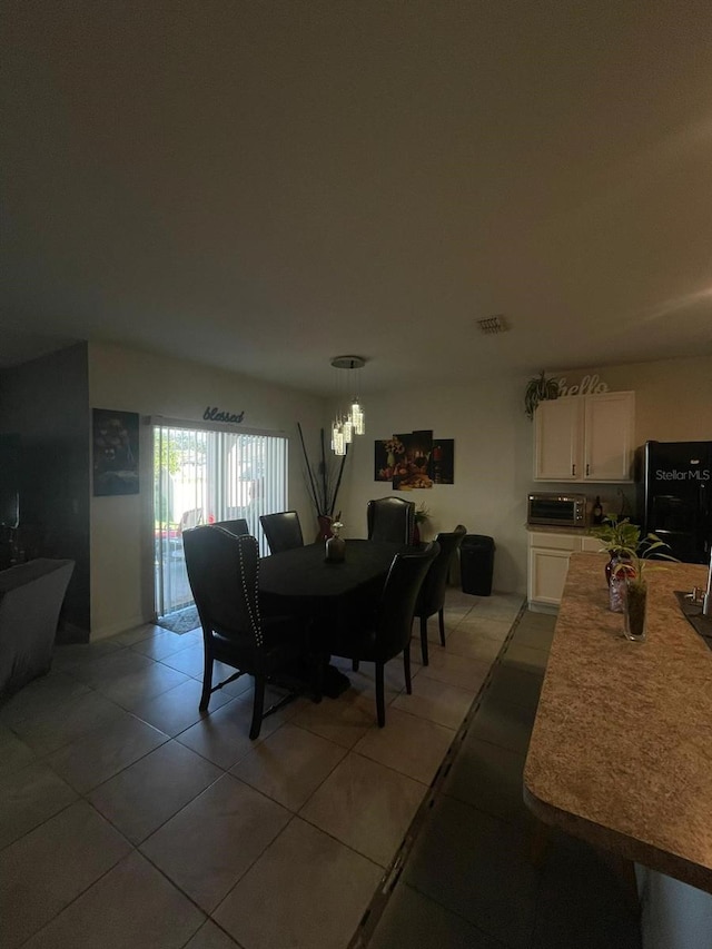 tiled dining area with a chandelier