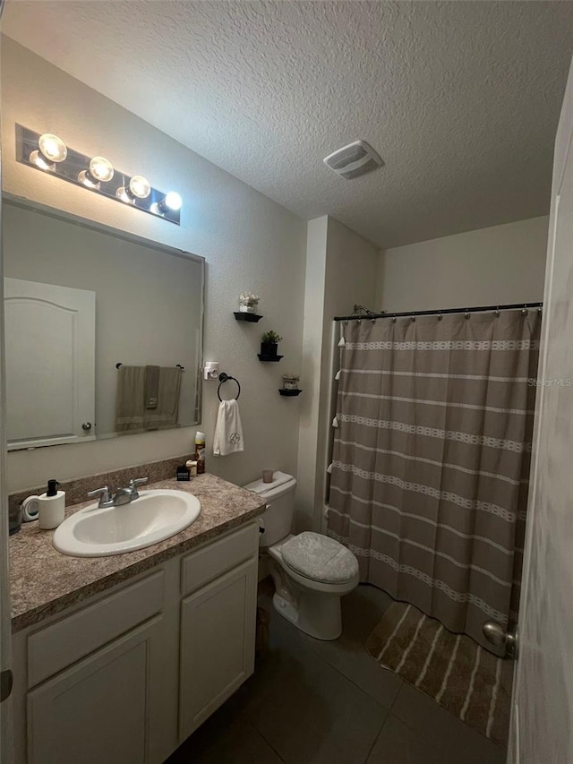 bathroom with tile patterned floors, toilet, a textured ceiling, vanity, and a shower with shower curtain