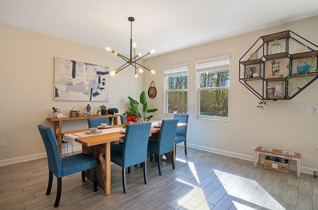 dining area featuring wood tiled floor, baseboards, and a chandelier