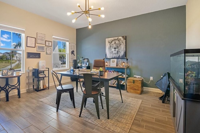 dining area featuring baseboards, a notable chandelier, and wood finish floors