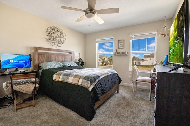 carpeted bedroom with ceiling fan and a textured ceiling