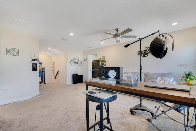 carpeted office space with ceiling fan and a textured ceiling