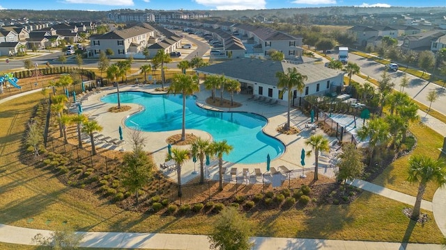 community pool featuring a patio area, a residential view, and fence