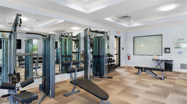 gym featuring a tray ceiling, visible vents, crown molding, and light carpet