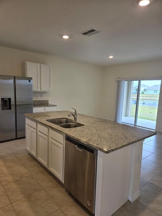 kitchen featuring white cabinetry, appliances with stainless steel finishes, sink, and an island with sink