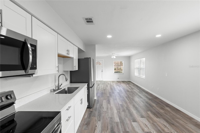 kitchen featuring sink, ceiling fan, white cabinetry, stainless steel appliances, and wood-type flooring