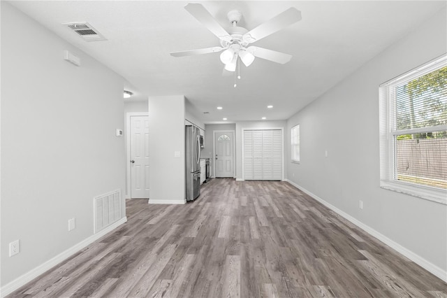 unfurnished living room featuring ceiling fan and light wood-type flooring