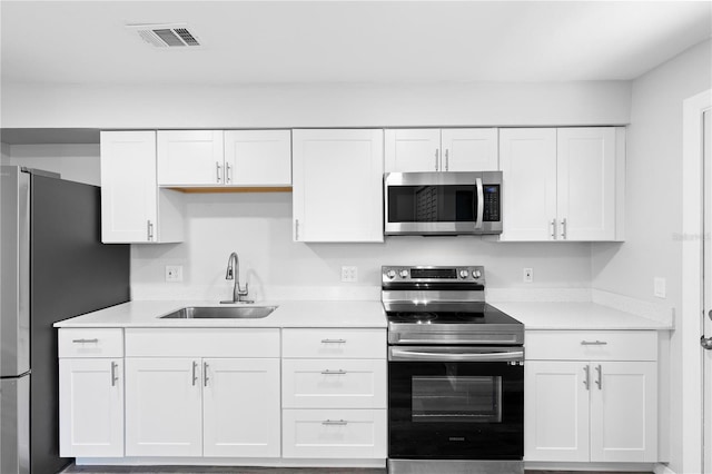 kitchen with stainless steel appliances, sink, and white cabinets