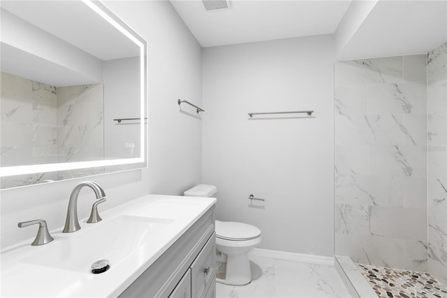 bathroom featuring vanity, toilet, and a tile shower