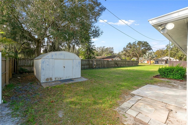 view of yard featuring a storage unit and a patio