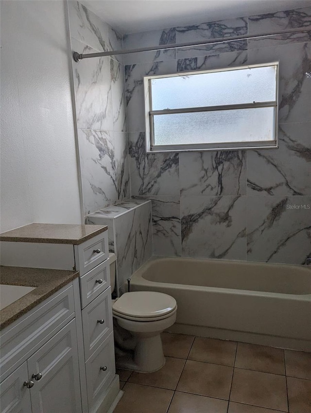 full bathroom with tiled shower / bath, vanity, toilet, and tile patterned floors